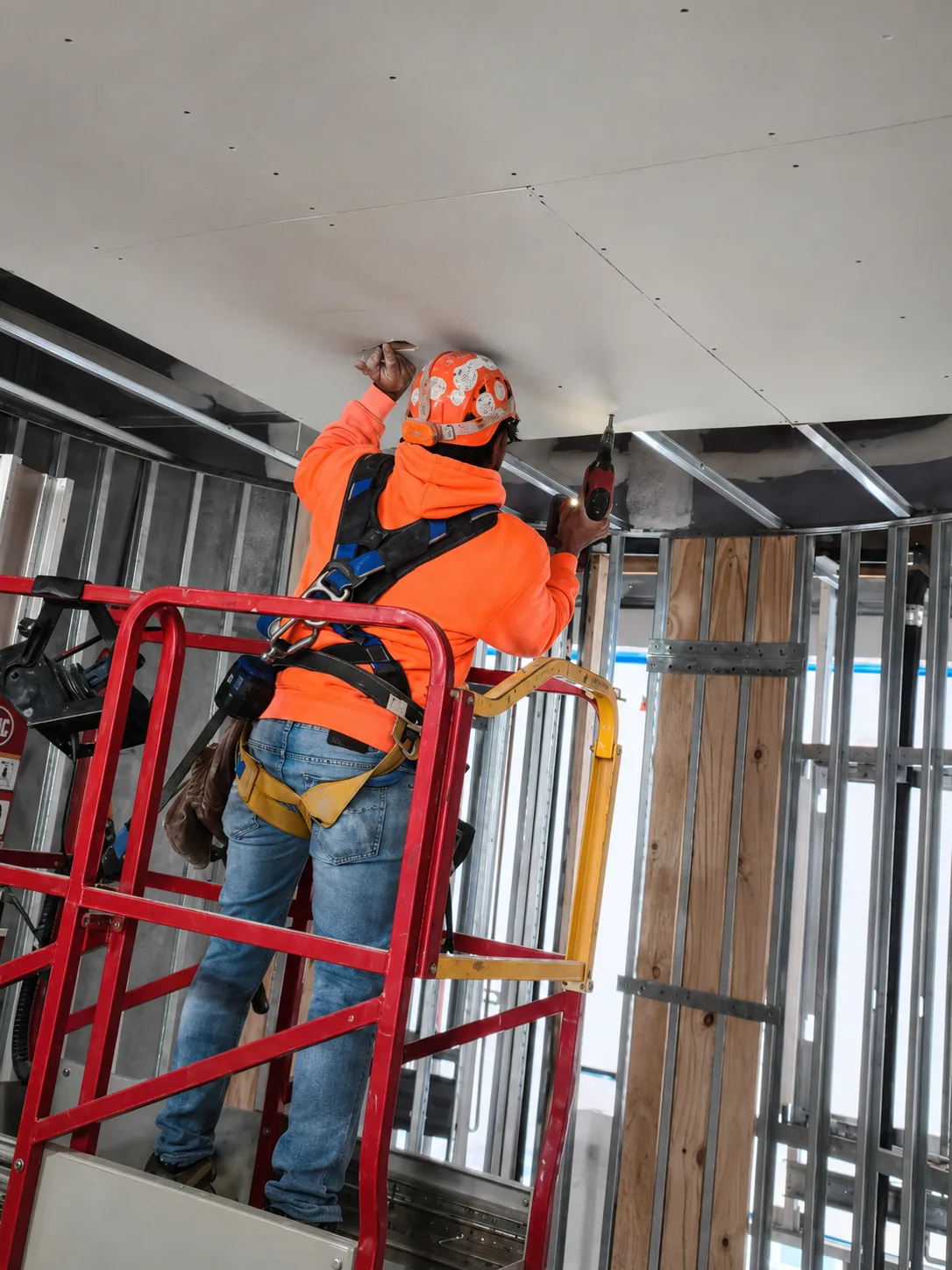 ARANDAS crew member installing ceiling drywall board on a commercial project