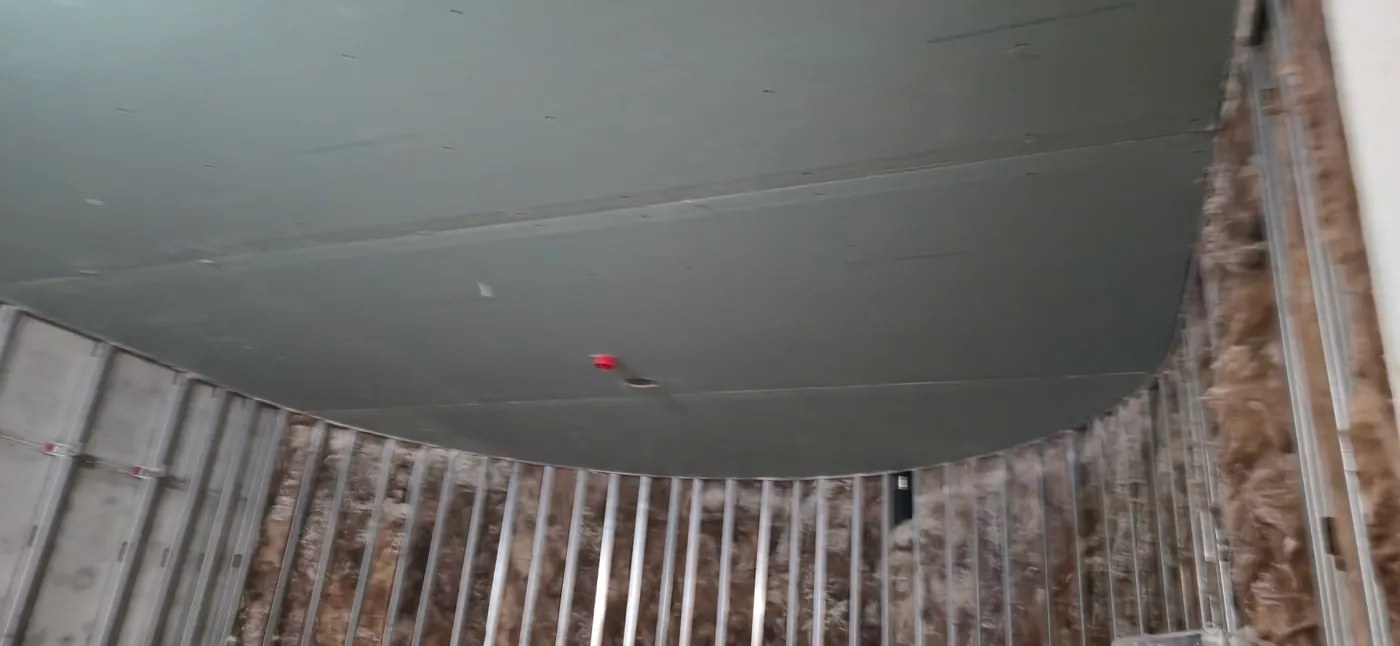 Curved commercial ceiling with drywall board installed over metal framing